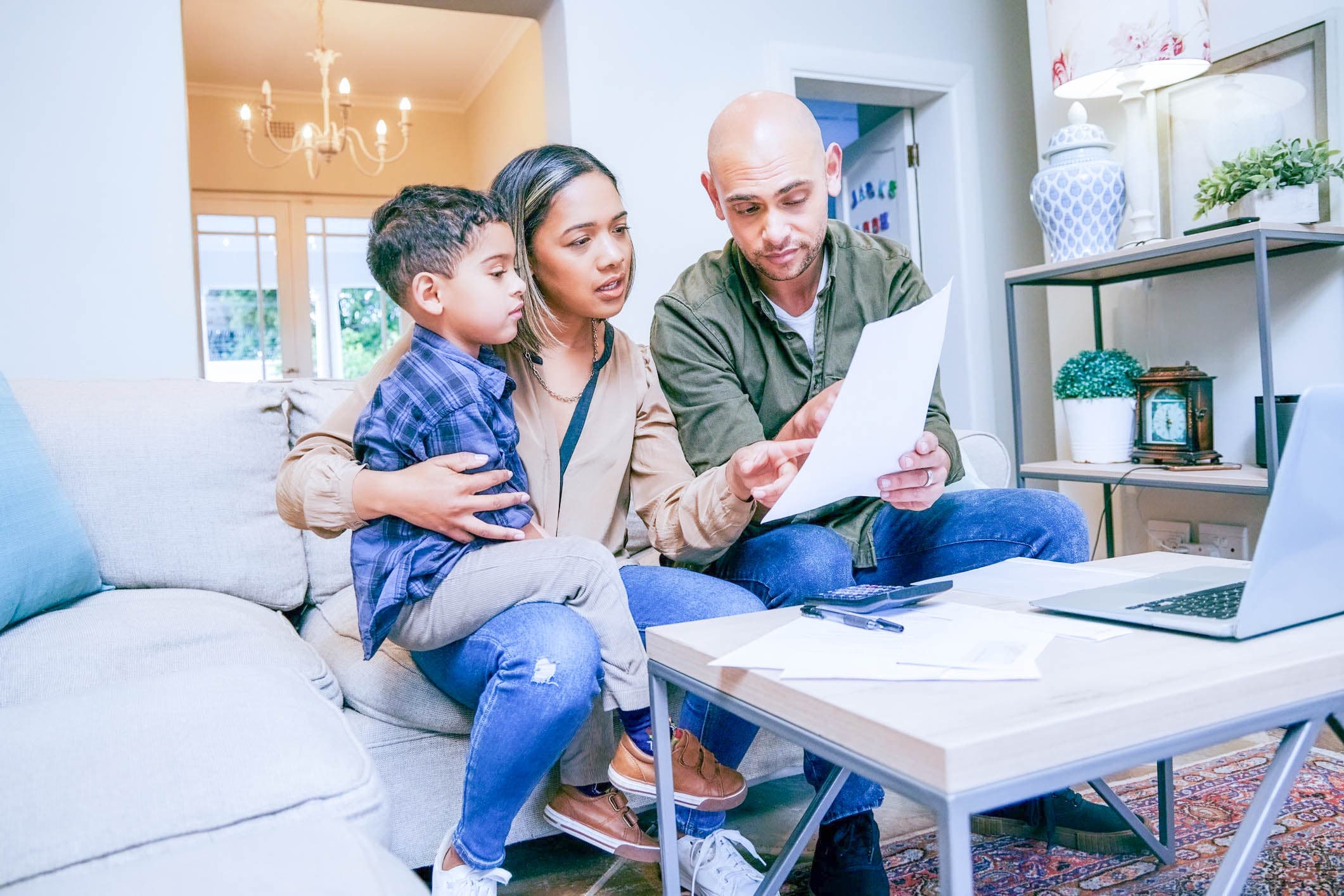 Parents and their son reviewing education expenses together at a laptop