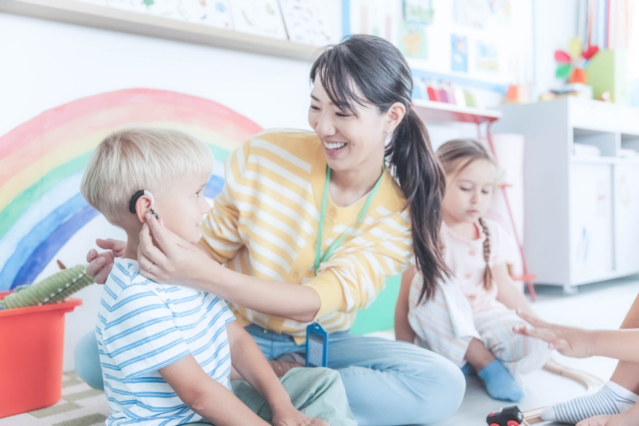 A teacher working with young students in a Christian school classroom